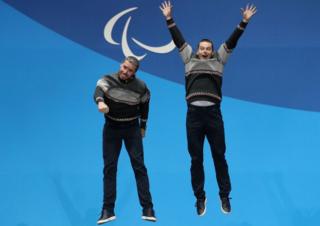 Alpine Skiing Men's Super Combined gold medallist Miroslav Haraus of Slovakia and his guide Maros Hudik jump in the air