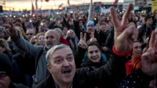 Crowds of people doing a peace gesture at the rally in Letna Park, Prague