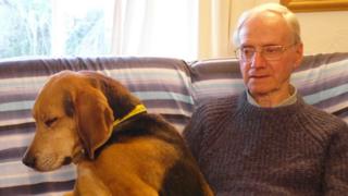 Peter Wrighton, seated, with a dog on his lap