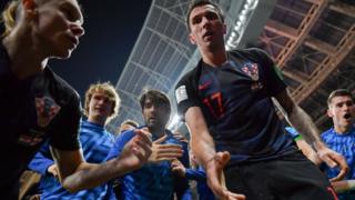 Miembros de la selección de Croacia ayudando a levantar del piso al fotógrafo Yuri Cortez