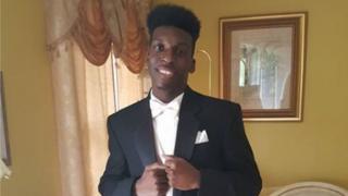 Photo of Emantic Bradford Jr in a tuxedo in front of his father's house