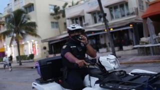 A Miami police officer wears a mask to enforce the city's mask mandate