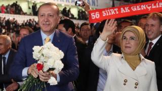Cumhurbaşkanı Recep Tayyip Erdoğan ile eşi Emine Erdoğan kongre salonuna gelen kalabalığı selamlıyor. Cumhurbaşkanı Erdoğan elindeki karanfilleri dağıtıyor.