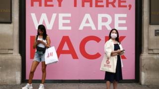 Two people with facemasks outside shop