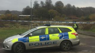 A forensics tent can be seen in the distance