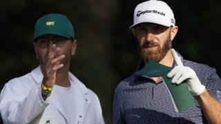 Dustin Johnson and his caddie