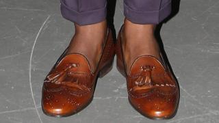 A man wearing shoes but no socks