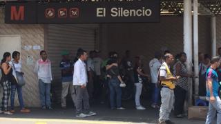 Estación del metro cerrada y una fila esperando el transporte en superficie.