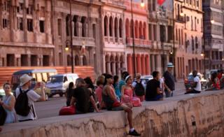 People gather along the Malecon to watch the sunset