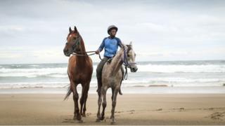 Lubabalo rides horses on the beach