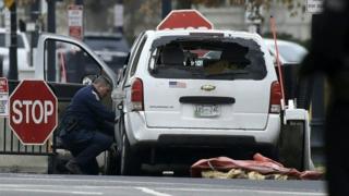 An agent inspects a passenger car sitting at a security barrier it struck near the White House in Washington, DC