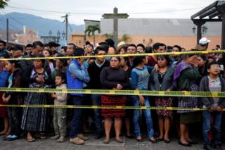 Residents stand behind the cordon line for safety
