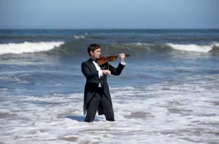 Musician Thoren Ferguson plays the Il Mare Violin, which is made from driftwood in the sea at Yellowcraigs, East Lothian
