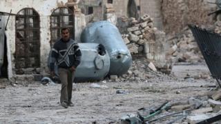 رجل يسير بين الحطام في حلب