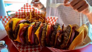 A huge stacked burger and fries