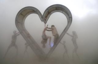 Burning Man participants perform a shibari rope scene during a driving desert dust storm inside the heart of the Identity Awareness - Family art project created by artist Shane Pitzer on the 2nd day of the annual Burning Man arts and music festival in the Black Rock Desert of Nevada, U.S. August 29, 2017