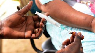 A nurse preparing to inject a measles vaccine in Senegal