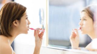 Mujer cepillándose los dientes