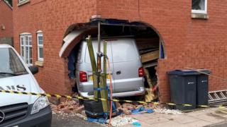 Van inside the property following the crash