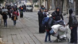 Residents of rebel-held Aleppo walk through the Qadi Askar district (30 November 2016)