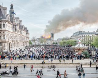 Crowds gather in Paris as the Notre Dame cathedral burns in the background