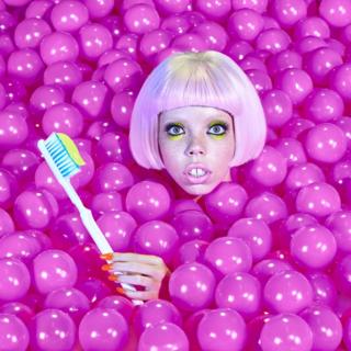 Woman in a pool of colorful plastic balls.