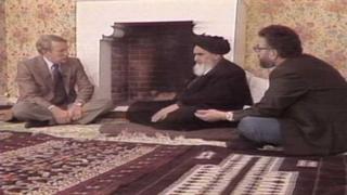مکنیل (چپ) میگوید تا آن روز از نزدیک یک آیتالله ندیده و مجبور نشده بود قبل از ضبط برنامه، کفشهایش را در بیاورد و در اتاقی خالی از اسباب و اثاثیه چهار زانو در کنار مصاحبه شونده روی زمین بنشیند