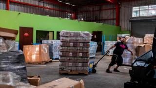 A man pulls a pallet of gas canisters in a warehouse in Ponce, Puerto Rico on January 18, 2020