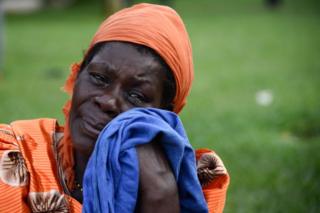 A woman crying on the emergency site of a capsized cruise ship on Lake Victoria in Mutima village, Uganda - November 26, 2018