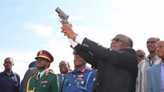 Rais Magufuli akifyatua risasi hewani kuashiria ufunguzi wa uwanja wa ndege vita nchini Tanzania