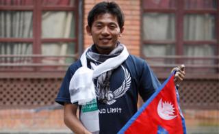 Japanese climber Nobukazu Kuriki poses with a Nepalese flag during a press conference in Kathmandu, Nepal, on 23 August