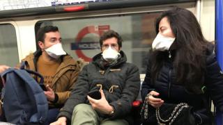 People wearing face masks on the London Underground, as the first case of coronavirus has been confirmed in Wales and two more were identified in England - bringing the total number in the UK to 19