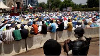 Malian riot policemen keep an eye on Muslims gathering for the Friday prayer in the Independence square in Bamako on June 5, 2020.