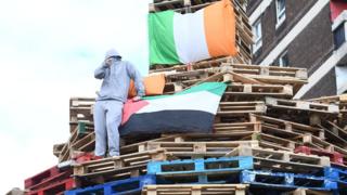 Youth on top of New Lodge bonfire