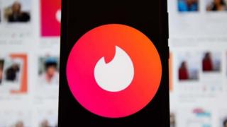 Tinder's logo displaying on a mobile phone.