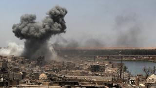 Дым вздувается после авиаудара под руководством американских международных коалиционных сил, нацеленного на группу Исламского государства (ИГИЛ) в Мосуле 9 июля
