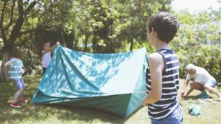Stock image of children building a makeshift tent