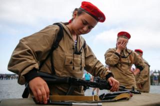 A girl in army wear concentrates on assembling a gun at the 2017 International Army Games.