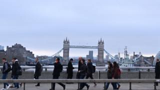 Commuters on a bridge over the River Thames in London