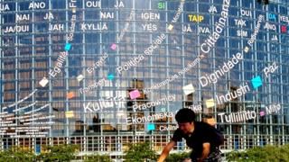 Cyclist going past slogans on the European Parliament building in Strasbourg