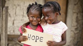 Girls holding a sign saying hope