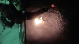 Crew being winched up to a helicopter