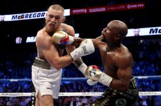Floyd Mayweather Jr. throws a punch at Conor McGregor during their super welterweight boxing match on 26 August 2017 at T-Mobile Arena in Las Vegas, Nevada.