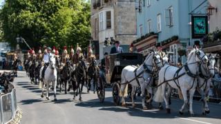 A carriage is pulled by four Windsor Grey horses from Windsor Castle during a dress rehearsal of the wedding of Prince Harry and Meghan Markle outside Windsor Castle on 17 May.