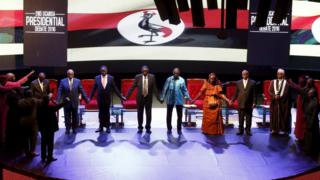 Uganda's presidential candidates hold hands as they pray before a presidential debate in Kampala