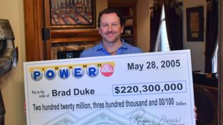 Brad Duke con una réplica del cheque que cobró