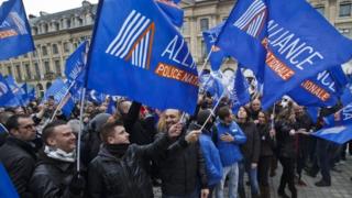 French police officers in Paris carry union flags next to the French justice ministry as part of their protest to demand better working conditions in Paris (14 October 2015)