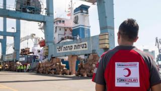 Man in Turkish Red Crescent shirt watching Lady Leyla ship unload