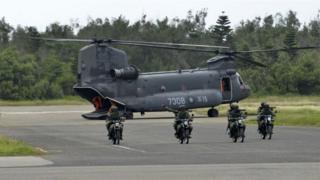 Armed Taiwanese soldiers ride on motorcycles next to a US-made CH-47 helicopter during the 'Han Kuang' (Han Glory) life-fire dril
