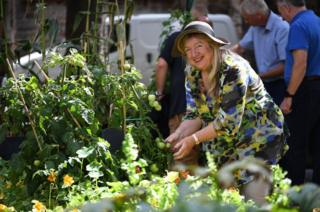 A volunteer admires one of the Parish's moveable pop-up allotments